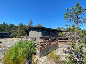 a cabin with a wooden deck in front of it at Rörvik Stugor in Geta