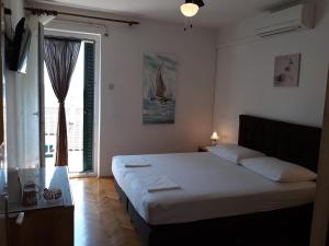 ein Schlafzimmer mit einem Bett und einem großen Fenster in der Unterkunft Bed & Breakfast Batosic Makarska in Makarska