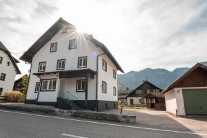 Ein weißes Haus an der Seite einer Straße in der Unterkunft Moderne Ferienwohnung mit Ausblick in Bad Goisern