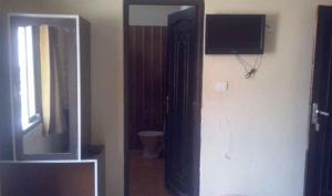 Habitación con espejo, TV y baño. en Hotel Radhika Palace en Uttarkāshi