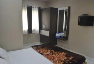 1 dormitorio con 1 cama y vestidor con espejo en Premium hotel near Nagoa Beach, en Diu