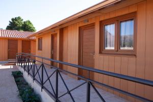 a building with a balcony with a door and windows at Hostal La Posada de Mari in La Cabrera