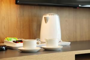 大田的住宿－Hotel Skypark DaejeonⅠ，桌上的两杯咖啡,放一个榨汁机
