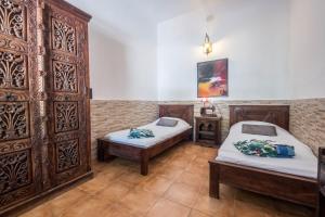 ギア・デ・イソラにあるCasa Cardón - Villa Perenquénのベッドルーム1室(ベッド2台、大きな木製キャビネット付)
