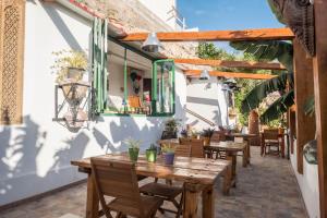 eine Außenterrasse mit Holztischen und -stühlen in der Unterkunft Casa Cardón - Villa Perenquén in Guía de Isora