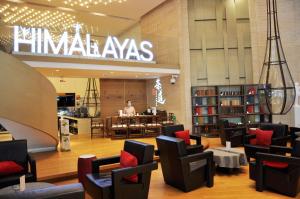 a library with a man sitting at a table at Himalayas Hotel Qingdao in Qingdao