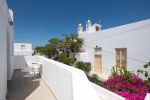 - Balcón con mesa y sillas en un edificio blanco en Lirous Studios, en Mykonos ciudad