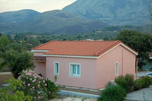 ポロスにあるBlue Lagoon Villaの山を背景にした小さなピンクの家