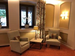 a waiting room with two chairs and a table and windows at Inselhotel Faakersee in Faak am See