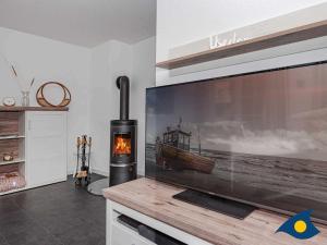 ein Wohnzimmer mit einem TV und einem Kamin in der Unterkunft Kirchstr 4a in Bansin