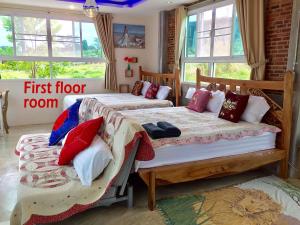 Dos camas en una habitación con ventanas. en KHAO KHO SKY WINDS, en Khao Kho 73 fotos más