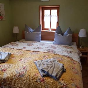 - une chambre avec un lit doté d'oreillers bleus et d'une fenêtre dans l'établissement Ökologische Ferienwohnung Becker, à Kottmar