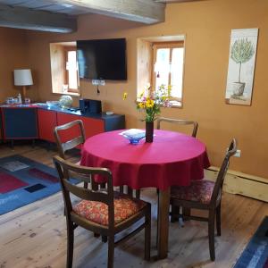 Ökologische Ferienwohnung Becker في Kottmar: غرفة طعام مع طاولة مع إناء من الزهور عليها