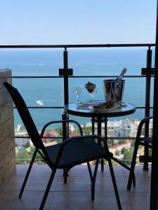 a table and chairs on a balcony with a view of the ocean at Panorama 44 in Odesa