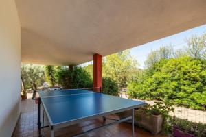 una mesa de ping pong en el patio de una casa en Casa vacanze Konemann, en Sarroch