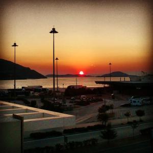 a sunset over a parking lot next to the water at Holiday Zigos in Igoumenitsa
