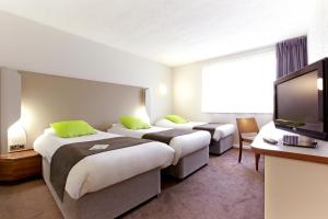 a hotel room with two beds and a flat screen tv at Campanile Bradford in Bradford