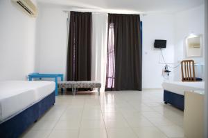 a hotel room with two beds and a window at West End Hotel in Peyia