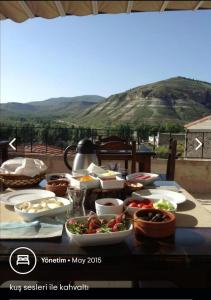 a table full of food with a view of a mountain at Monte Cappa Cave House in Urgup