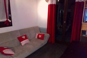 salon z kanapą i czerwonymi poduszkami w obiekcie appartement en chalet au pied des pistes w mieście La Norma