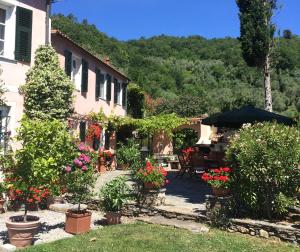 ein Haus mit Blumen und Pflanzen im Hof in der Unterkunft Villa Barca - Luxury Vacation Rentals - Wellness & Pool in Casanova Lerrore