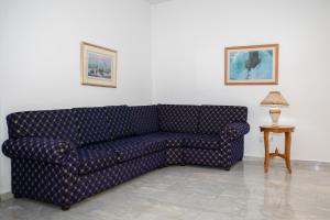a blue couch in a living room with a table at West End Hotel in Peyia