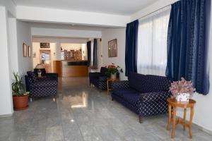 a living room with blue furniture and blue curtains at West End Hotel in Peyia
