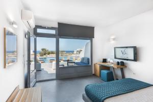 a bedroom with a bed and a view of a pool at Volcanic Arc Suites in Oia