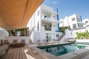 an external view of a villa with a swimming pool at Casa Aguila Ibiza in Cala Vadella