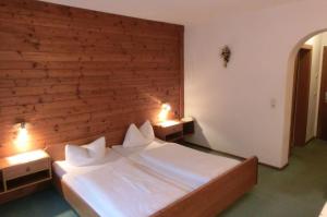 a bedroom with a large bed with two night stands at Gästehaus Hollerer in Gerlos