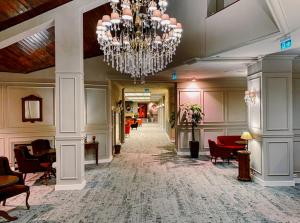 a hallway with a chandelier in a hotel lobby at Poiana Brasov Alpin Resort Apartment in Poiana Brasov