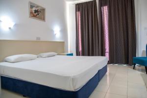 a bedroom with a bed and a window at West End Hotel in Peyia