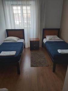 a bedroom with two beds and a window at Areia Da Foz in Figueira da Foz
