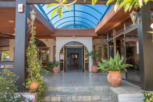 a lobby with potted plants and a blue ceiling at West End Hotel in Peyia