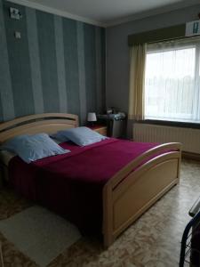 a bedroom with a large bed with a purple blanket at B & B Vandenbroucke Joseline in Ieper