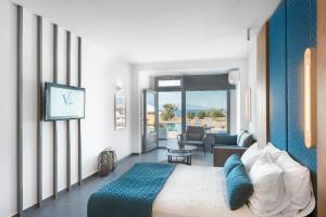 a bedroom with a bed and a living room at Volcanic Arc Suites in Oia