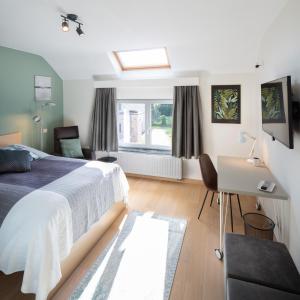 Schlafzimmer mit einem Bett, einem Schreibtisch und einem Fenster in der Unterkunft Barbara's Bed & Breakfast in Sterrebeek