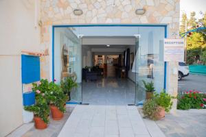 a entrance to a building with potted plants at West End Hotel in Peyia