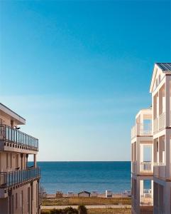 a view of the ocean from between two buildings at Strandpark Seeanemone im Haus Windrose 11 in Großenbrode