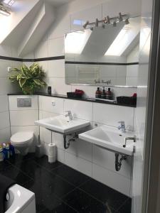 a bathroom with two sinks and a toilet at Apartment mit Parkblick in Tönisvorst