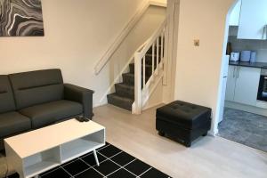 a living room with a couch and a stool at Spacious & Luxurious 1 bed House in Thamesmead in Thamesmead