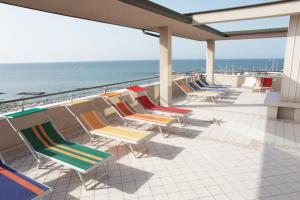 eine Sitzreihe auf einem Balkon mit Meerblick in der Unterkunft Hotel Acropolis in Cattolica