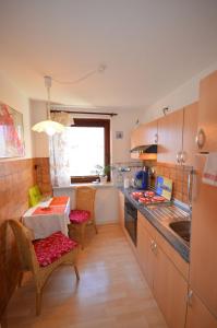 a kitchen with wooden cabinets and a table with chairs at Ferienwohnung Hummer im Haus Daheim in Helgoland