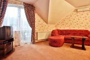 a living room with a red couch and a tv at U Anity in Uzhhorod