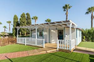 a white house with a porch and a white fence at Ilunion Islantilla in Islantilla