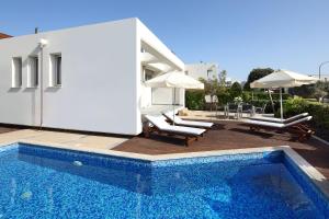 a villa with a swimming pool and a house at Paradise Cove Luxurious Beach Villas in Paphos City