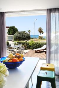 a bowl of fruit sitting on a table on a patio at Paradise Cove Luxurious Beach Villas in Paphos