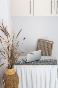 einen Tisch mit einem Laptop und einer Vase darauf in der Unterkunft Hotel Villa Flora in Naxos Chora