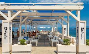 a white pavilion on the beach with people and horses at Apartment Porpo in Malinska