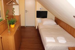 a small room with two beds and a tv at Altan Hotel in Hamburg